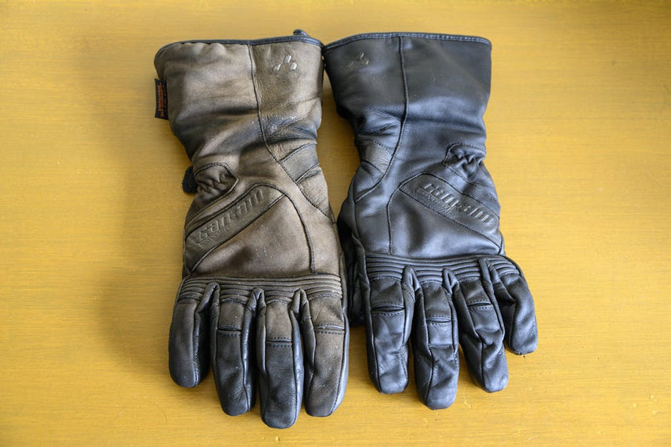 A pair of leather motorcycle gloves laying flat on a table the right hand glove is untreated and looks old and dirty. The left hand glove is treated with Leather better and is looking brand new again.