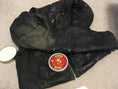 Load image into Gallery viewer, Black leather jacket laying flat on a table with half of the jacket being treated with Leather better. A can of Leather better is on the jacket on the bottom left corner.