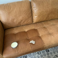 Load image into Gallery viewer, A tan faded leather couch with an open can of Leather better with a rag on top of a treated patch of the faded couch.