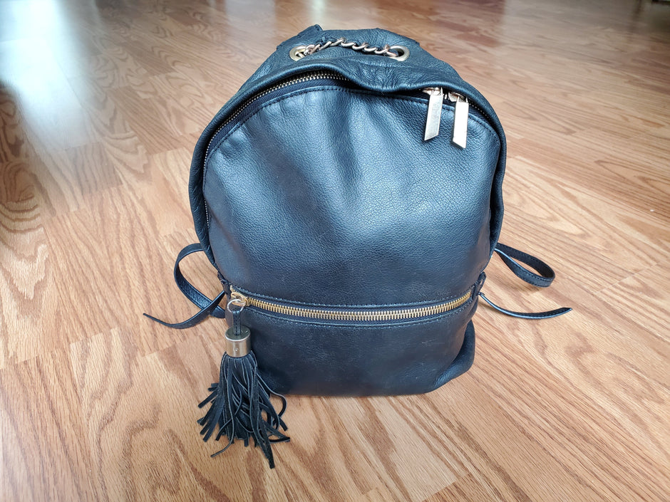 Restored blue leather backpack with a rich, even finish and smooth texture. The leather looks conditioned and revitalized, with the colour deepened and surface shine restored.