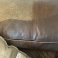 Load image into Gallery viewer, A top view of a chocolate brown leather couch cushion that has the bottom half treated and the top untreated to show the results.