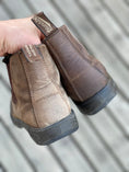 Load image into Gallery viewer, Customer Lisa is holding up her Blundstones for a selfie.  Only one has been treated and the results are obvious.  Lisa's five star review: "This impressed me. Brought shoes back to life that I’d been about to toss..and weeks later they still look great!  I’ve tried other products that have only lasted for a few wears…not this one!"
