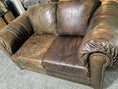 Load image into Gallery viewer, A leather love seat with oversized arms.  The love seat is half treated.  The left is the before and the right is the after with the deep chocolate brown restored and the scratches gone.
