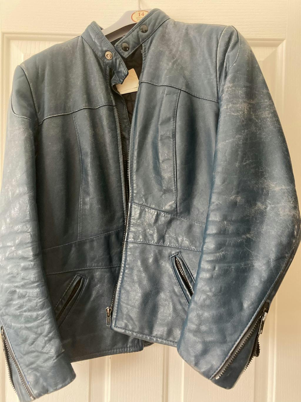 A faded blue motorcycle jacket prior to being treated with Leather Better.