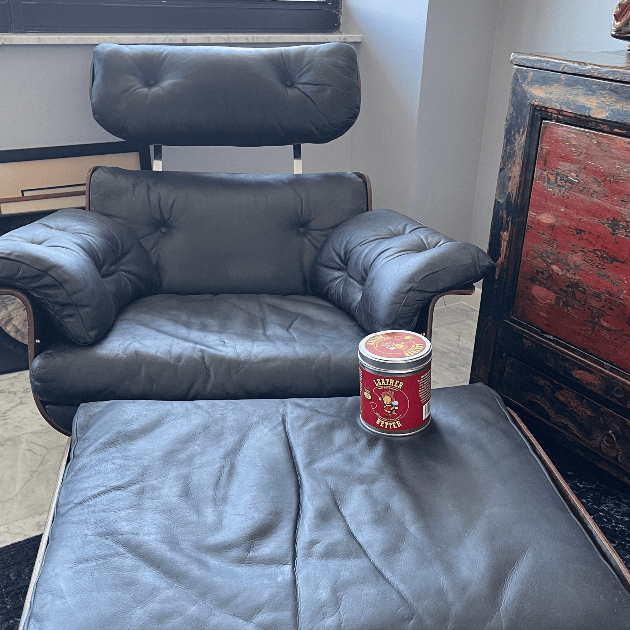 A restores grey armchair and ottoman after being treated with Leather Better.