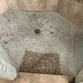 Load image into Gallery viewer, Before and after of a shower floor, the lower section cleaned and restored, compared to the untreated upper area. Shelley's five star review: "I borrowed a can of Leather Better from a friend to revitalize the knotty alder cabinets in my kitchen.  On a whim, I decided to use it on my granite mosaic tiled shower as it had lost its depth of colour over the years of use.  Surprise! My shower looks like the day it was built and with no slippery finish!  So glad I took a chance and used it unconventionally!"
