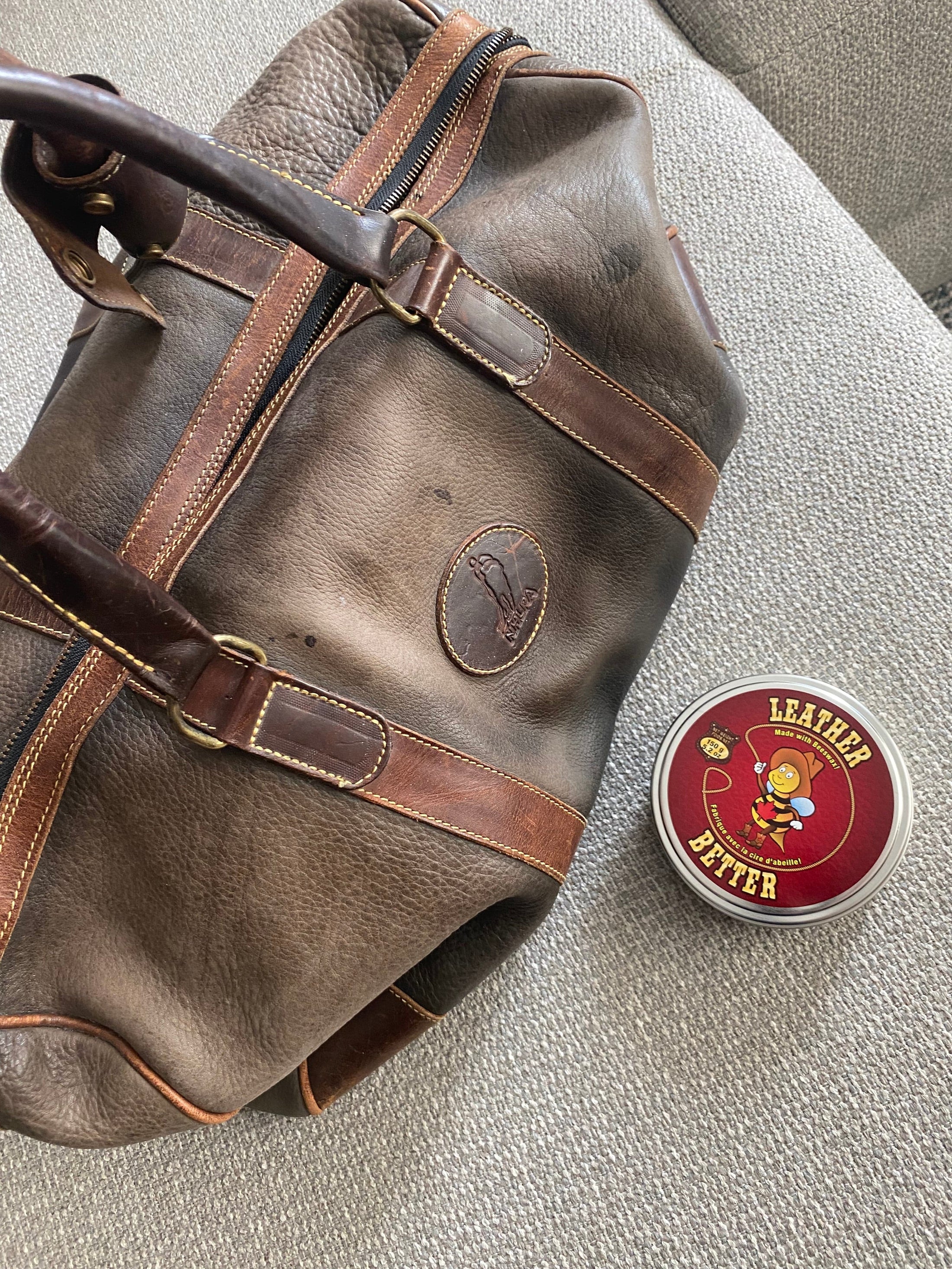 A faded leather weekender bag prior to being treated with Leather Better.