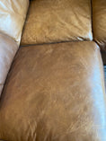 Load image into Gallery viewer, A close up of the seat section on a leather couch showing numerous scratches from a dog, prior to being treated with Leather Better.
